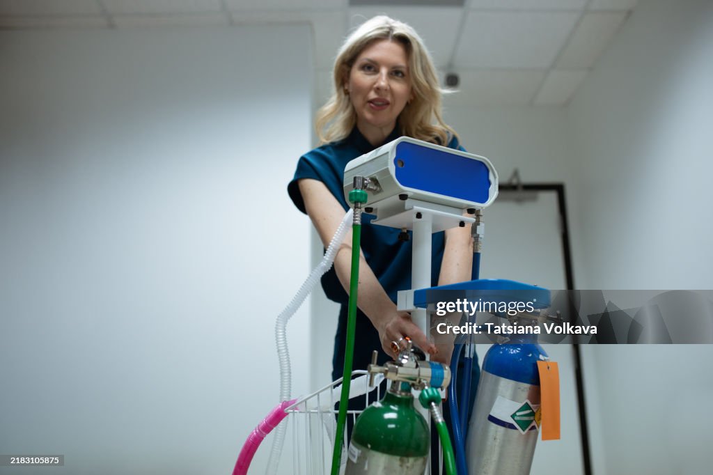 Woman in medical attire setting up a gas-based system for pain relief, combining oxygen and nitrous oxide for patient comfort.