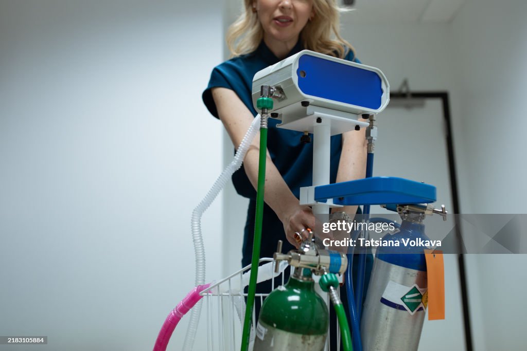 Doctor preparing a nitrous oxide system for pain relief, offering patient comfort through a safe oxygen-nitrous oxide blend.