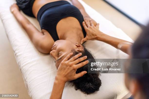 chiropractor curing patient's neck and shoulder pains using massage - kinésithérapie photos et images de collection