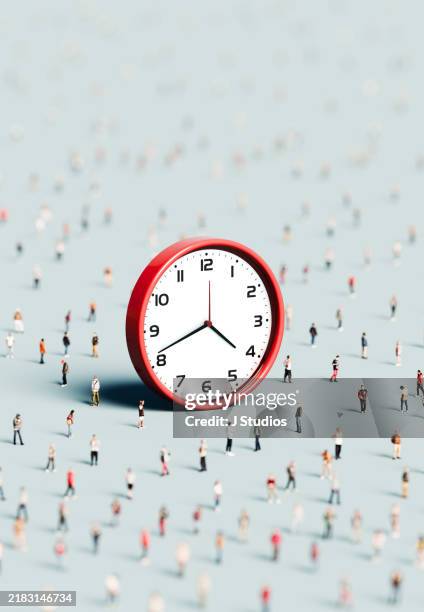 large group of people surrounding an oversized clock - corsa contro il tempo foto e immagini stock