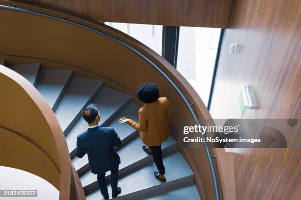 collègues de travail discutant sur un escalier en colimaçon - escalier photos et images de collection