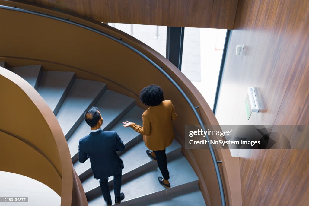 Business Colleagues Discussing on Spiral Staircase