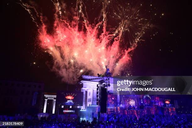 Fireworks ligthen the sky over the Brandenburg gate as musicians play on stage during the Konzert für Freiheit" for the 35th anniversary of the fall...