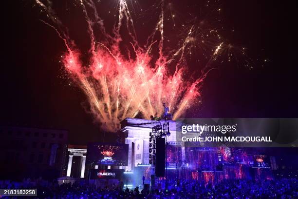 Fireworks ligthen the sky over the Brandenburg gate as musicians play on stage during the Konzert für Freiheit" for the 35th anniversary of the fall...