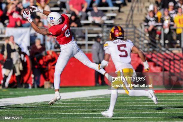 Ian Strong of the Rutgers Scarlet Knights catches a pass while being defended by Justin Walley of the Minnesota Golden Gophers during the second half...