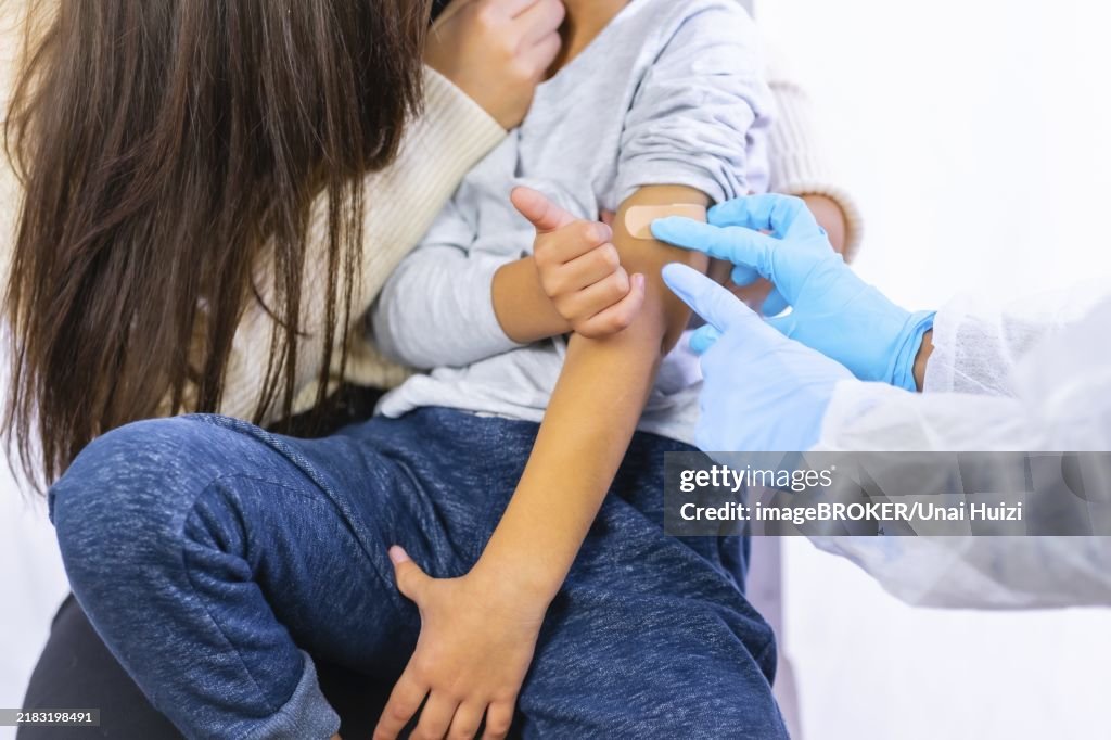 Scared child after vaccination injection by a female doctor. Vaccination of children. Immunization in the coronavirus pandemic, covid-19