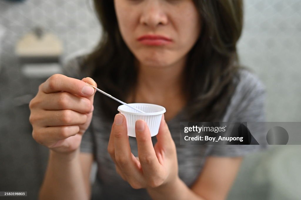 Cropped shot view of unhappy woman while using a LH ovulation test strip. Tests Strips give accurate and clear results for the possibility of pregnancy.