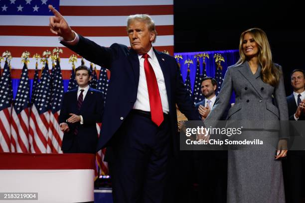 Republican presidential nominee, former U.S. President Donald Trump points to supporters with former first lady Melania Trump during an election...
