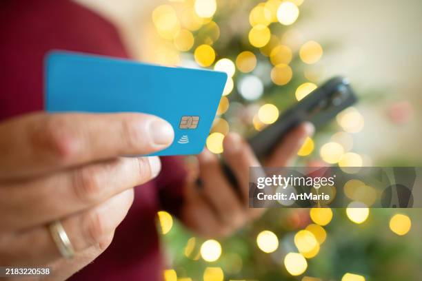 man with smartphone and credit card near christmas tree - credit card art stock pictures, royalty-free photos & images