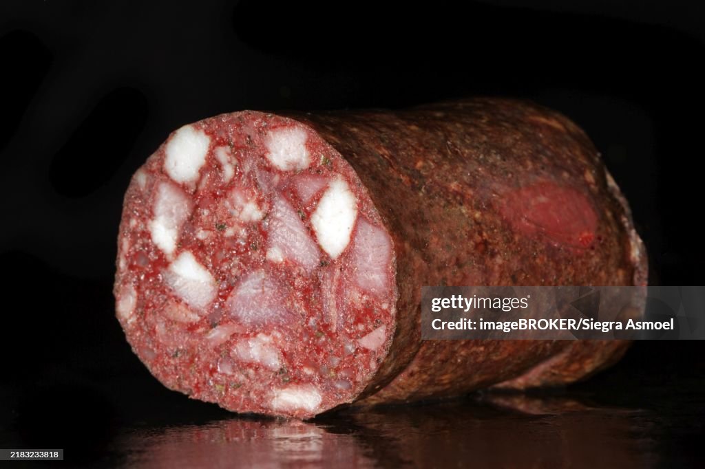Cut Thuringian red sausage, black pudding, studio photography with black background
