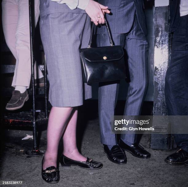 The legs of men and a woman dressed retro mod style at the Mousetrap club night, London, circa 1995.
