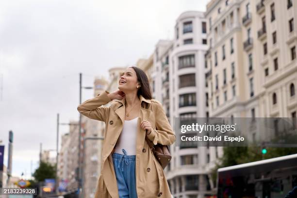 tourist walking in gran via enjoying madrid architecture - trench coat stock pictures, royalty-free photos & images