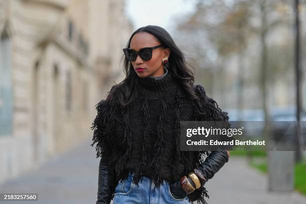 Emilie Joseph wears black sunglasses, chocolate Wool blended fringed turtleneck jumper from COS, black leather gloves, chocolate and golden bangles /...