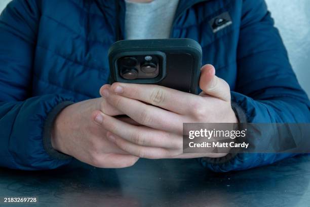 Year-old boy looks at a iPhone screen on October 20, 2024 in Portsmouth, England. The amount of time children spend on screens each day rocketed...