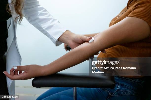 enfermera colocando una almohadilla de algodón donde extraer sangre - donacion sangre fotografías e imágenes de stock