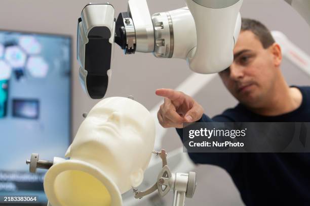 Robotics for orthopaedics and neurosurgery demonstrates at the Kuka booth of the Duesseldorf trade fair center in Duesseldorf, Germany, on November...