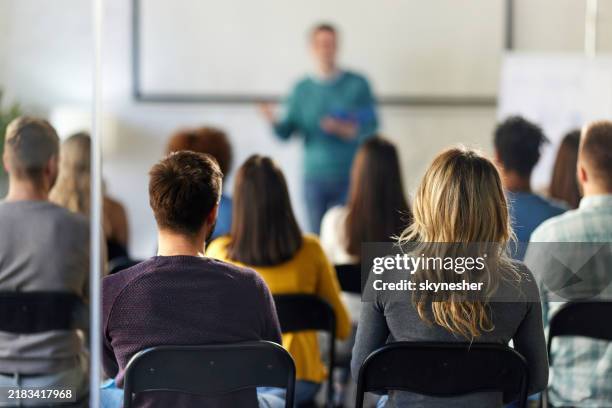 rear view of business colleagues attending a seminar in board room. - palestra imagens e fotografias de stock
