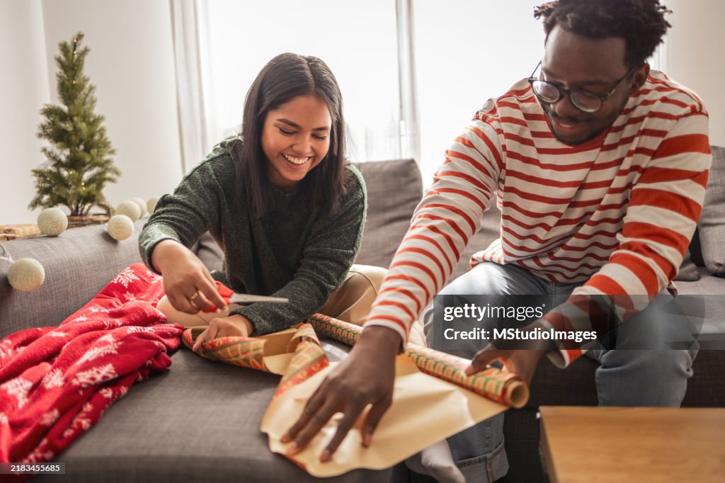 Pareja joven empacando regalos para familiares y amigos