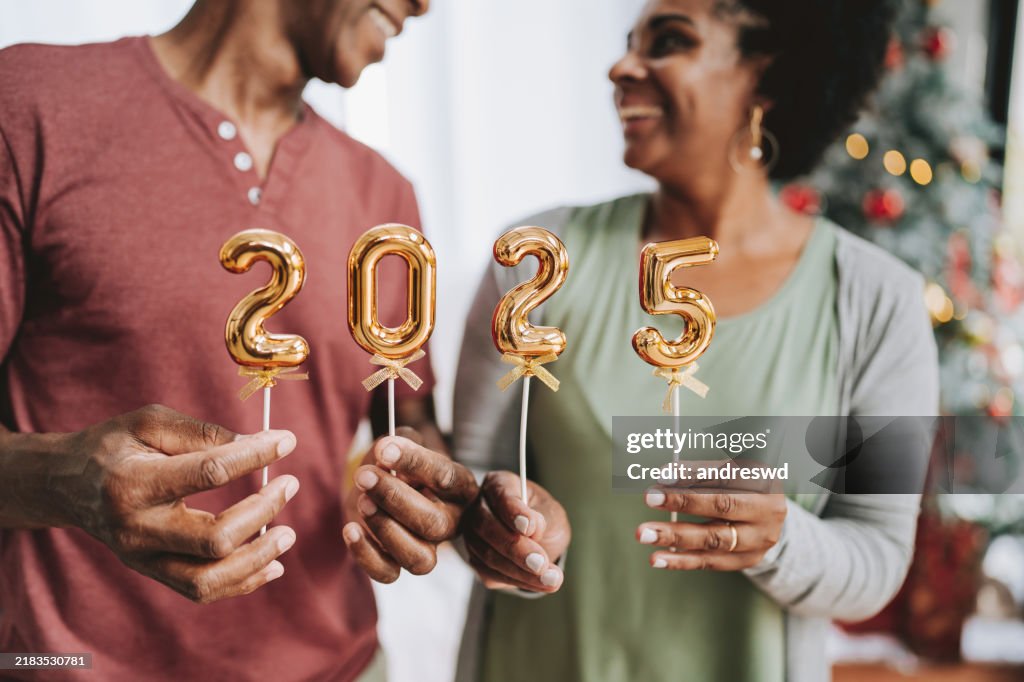 Couple d’âge mûr tient le numéro 2025 nouvel an