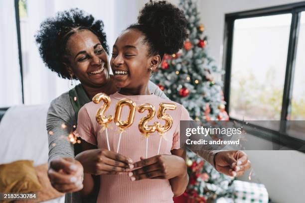 mutter und tochter halten die nummer 2025 für das neue jahr - neujahrsvorsatz stock-fotos und bilder