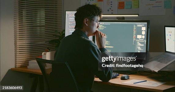 Programmer Reviewing Code with Multiple Screens. Programmer Reviewing Code with Multiple Screens.