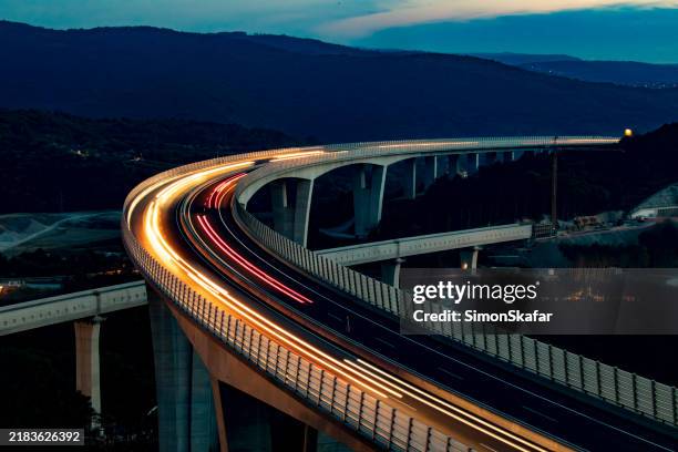tráfico nocturno que fluye a través de un amplio viaducto - estructura de edificio fotografías e imágenes de stock