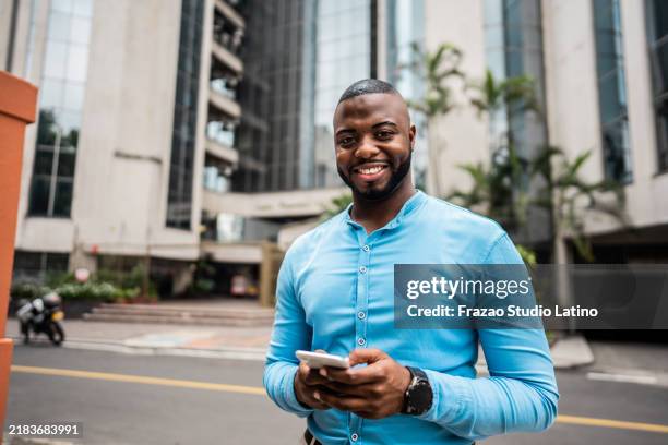 portrait of a young businessman using mobile phone in the city - cali colombia stock pictures, royalty-free photos & images
