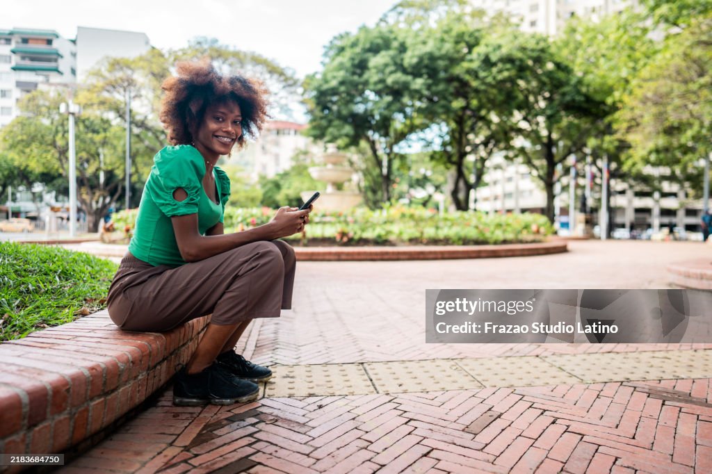 Portrait of a young woman using mobile phone outdoors