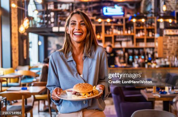 young woman holding a plate with a tasty burger - serving size stock pictures, royalty-free photos & images