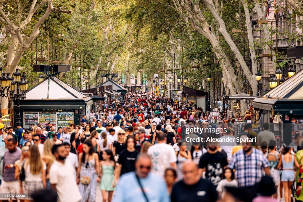 Crowds of tourists on La Rambla pedestrian street in summer, Barcelona, Catalonia, Spain