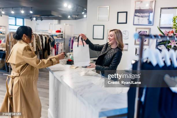 el propietario de una pequeña empresa boutique ayuda al cliente - colección de la moda fotografías e imágenes de stock