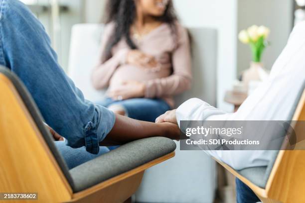 des parents adoptifs potentiels se tiennent la main lors d’une rencontre avec une femme enceinte - remplacement photos et images de collection