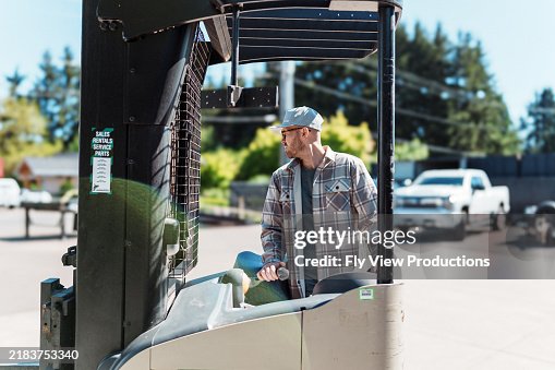 Forklift operator working outdoors at warehouse loading dock Forklift operator working outdoors at warehouse loading dock