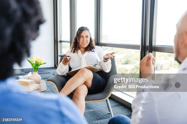 aufmerksames, nicht wiederzuerkennendes paar hört dem berater während der eheberatungssitzung zu - eheberatung stock-fotos und bilder