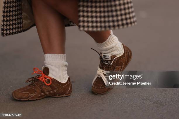 Karin Teigl is seen wearing an ankle-length black and white houndstooth patterned wool coat from the Gucci x New York Yankees collection; white...