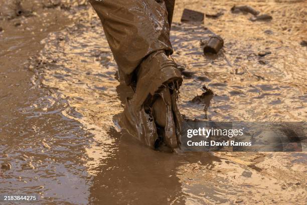 Volunteer walks through a mud-covered street as the area recovers from last week's widespread flooding on November 09, 2024 in the municipality of...