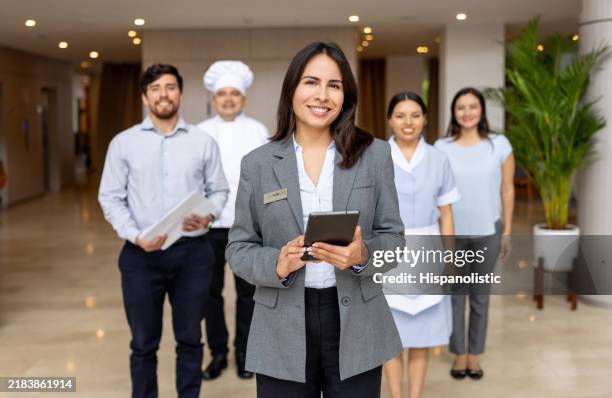 hotelmanager, der eine gruppe von mitarbeitern in der lobby führt - hotel stock-fotos und bilder