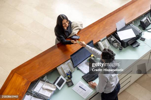 mujer que viaja por negocios y paga con tarjeta en el hotel - hotel fotografías e imágenes de stock