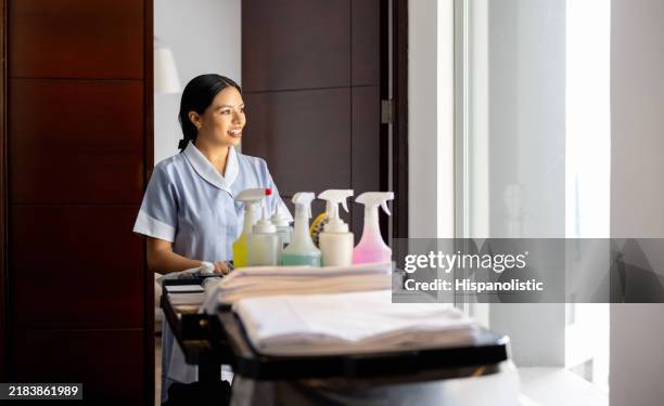 maid working at a hotel and smiling while pushing a cart with cleaning products - laundry-detergent-containers stock pictures, royalty-free photos & images
