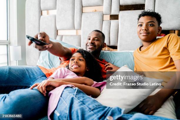 family watching tv on bedroom at home - streaming service stock pictures, royalty-free photos & images