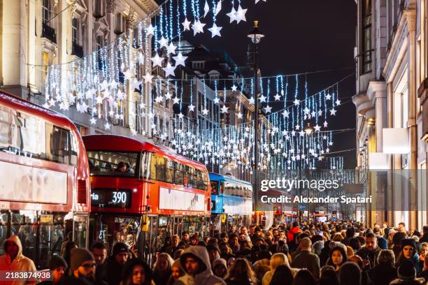 oxford street with shops and crowds of people decorated with christmas lights, england, uk - crowd of people stock pictures, royalty-free photos & images