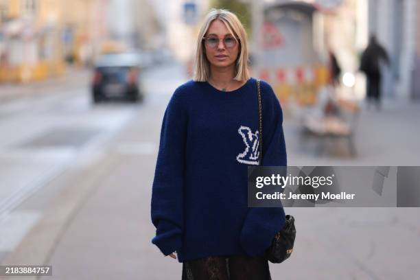Karin Teigl is seen wearing square-shaped sunglasses with a transparent frame and grey lenses from Jacques Marie Mage, a yellow gold “Alhambra”...