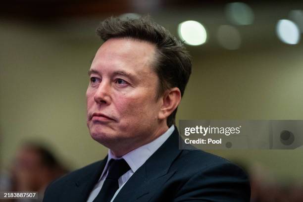 Elon Musk listens as US President-elect Donald Trump speaks during a House Republicans Conference meeting at the Hyatt Regency on Capitol Hill on...