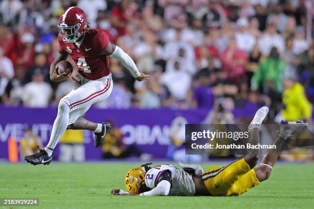 Jalen Milroe of the Alabama Crimson Tide runs with the ball as Jardin Gilbert of the LSU Tigers defends during the first half at Tiger Stadium on...