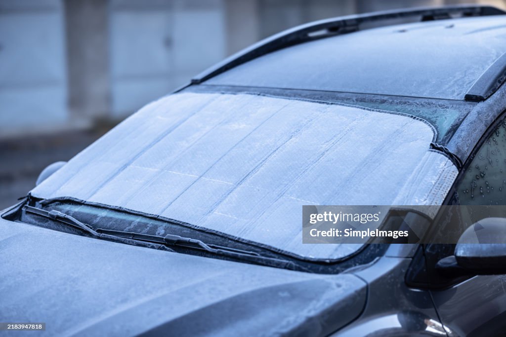 The protective aluminum foil on the car's windshield protects the glass from morning frost.