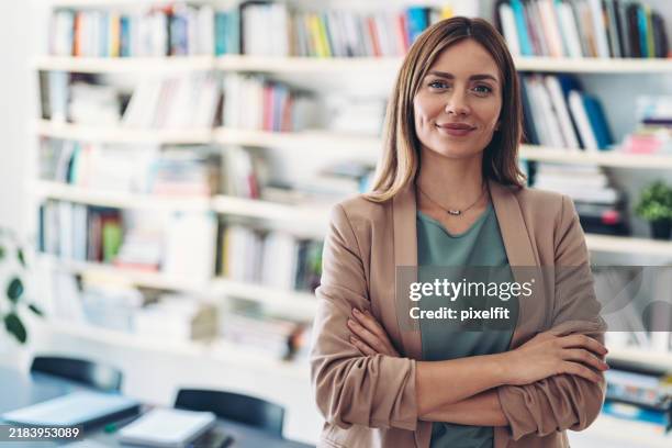 retrato de una mujer sonriente frente a una biblioteca - líder fotografías e imágenes de stock