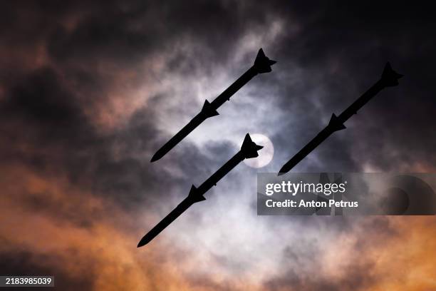 cruise missiles against a smoky sky - luftangriff stock-fotos und bilder
