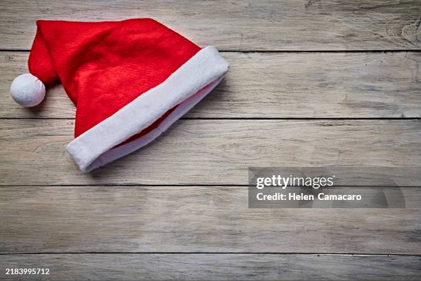 santa hat on rustic wooden table with copy space. - santa hat stock pictures, royalty-free photos & images