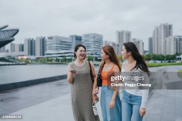 happy generation z girls tavelling in zhuhai, greater bay area, china, are looking for place to visit and asking advice from ai assistant on a mobile app using voice (speech recognition) - hotel shuttles stock pictures, royalty-free photos & images