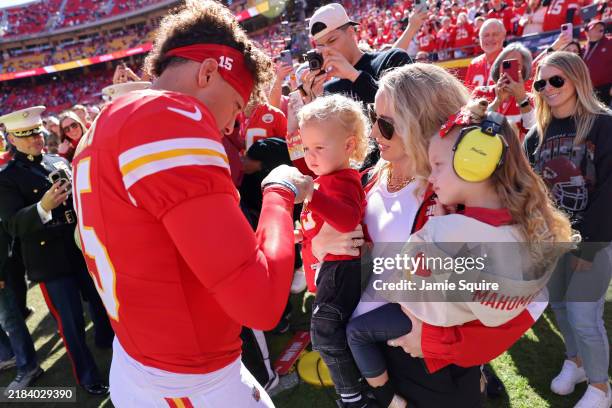 Patrick Mahomes of the Kansas City Chiefs fist bumps his son, Bronze, while his wife and daughter, Brittany and Sterling, watch prior to a game...